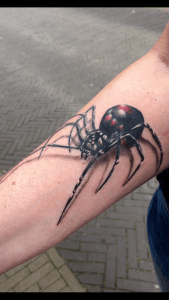 Realistische zwarte weduwe spin met 3D-effect op onderarm.