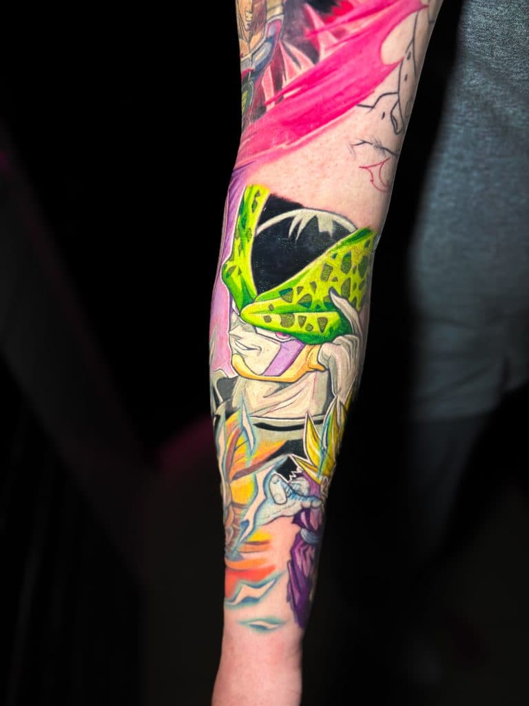 Kleurrijke Dragon Ball Z tattoo met Cell en Vegeta op de onderarm.