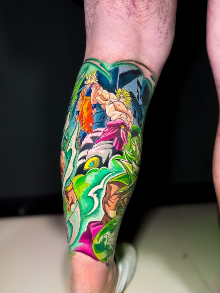 Kleurrijke Dragon Ball Z tattoo met Goku en Broly op onderbeen.