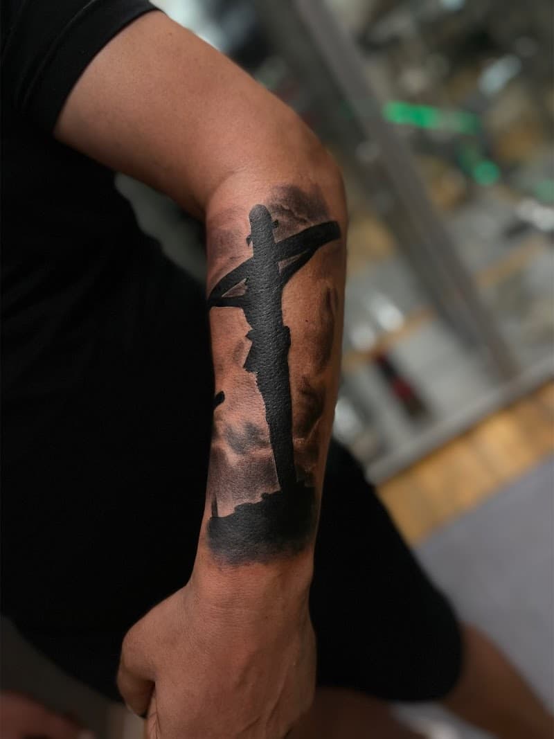 Silhouet van Jezus aan het kruis op de onderarm.