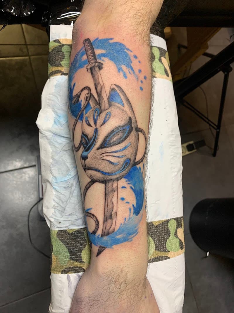 Kitsune masker met katana en blauwe golven op onderbeen.
