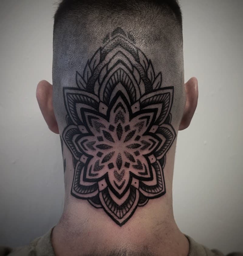 Grote mandala tattoo in dotwork en blackwork op het achterhoofd en nek.