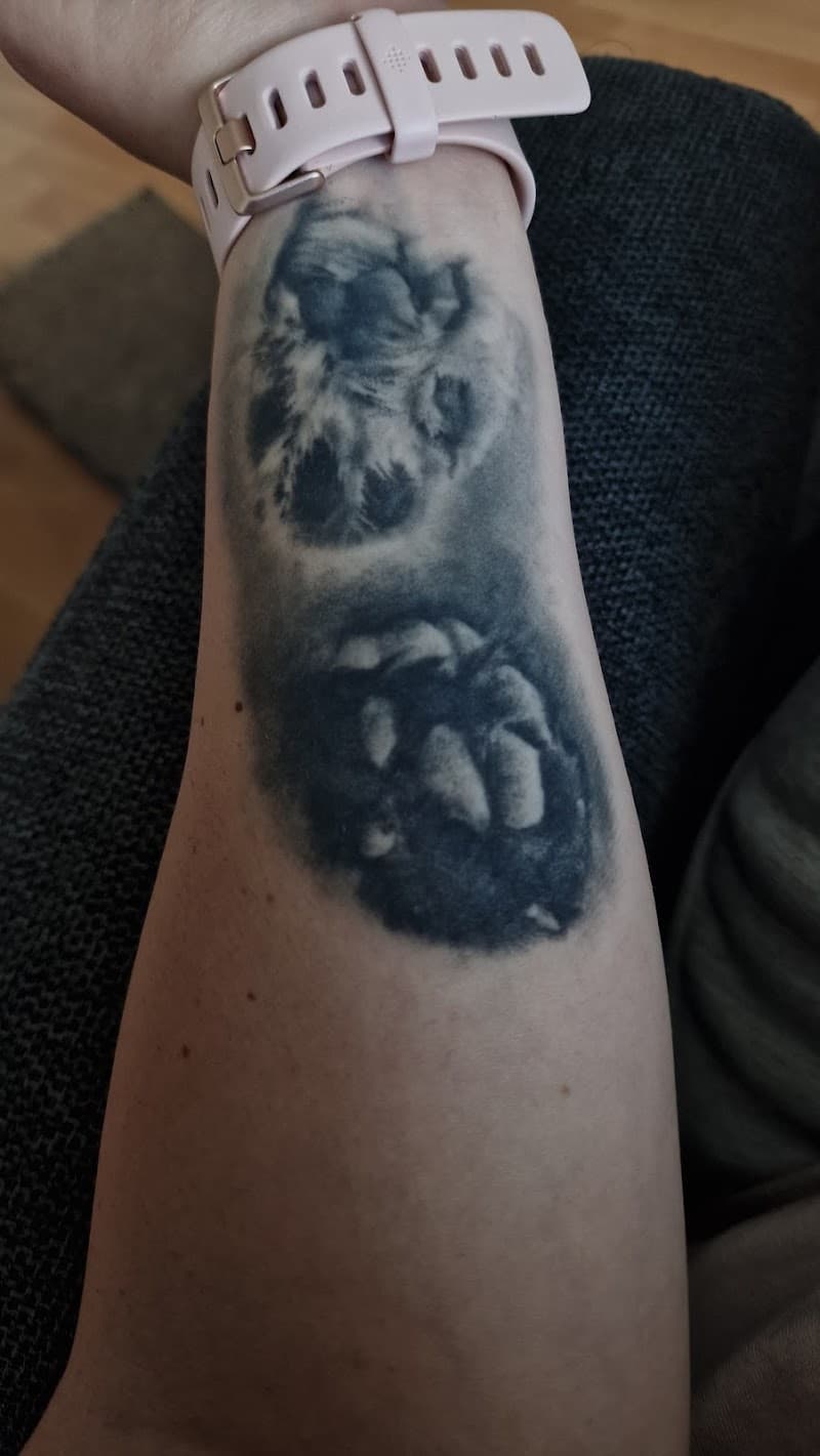 Twee realistische pootafdrukken op de onderarm.