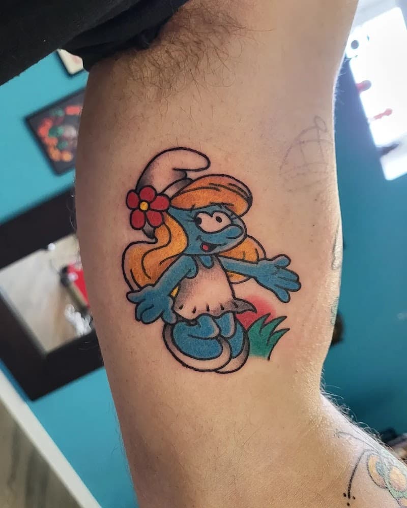 Kleurrijke Smurfin tattoo op de binnenkant van de bovenarm.
