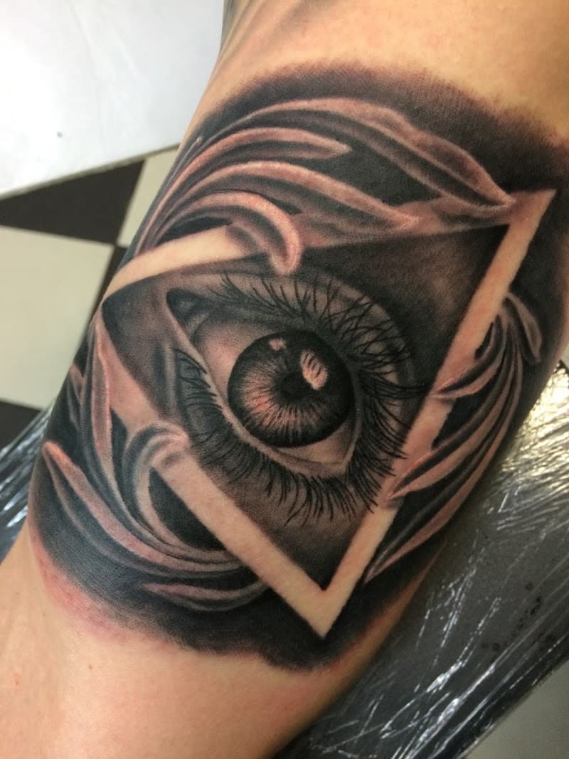 Realistisch oog in een driehoek met ornamenten.