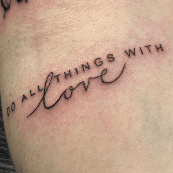 Fineline tekst tattoo met de quote 'DO ALL THINGS WITH love'.