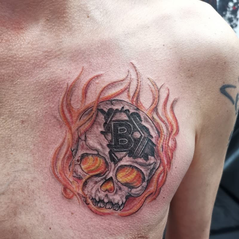 Schedel met vlammen en een 'B' logo erin verwerkt op de borst.