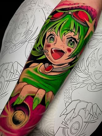 Kleurrijke anime tattoo van een lachend meisje met groen haar.