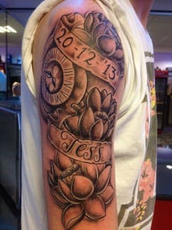 Zwart-wit half-sleeve met lotusbloemen, een klok en banners met 'Tess' en een datum.