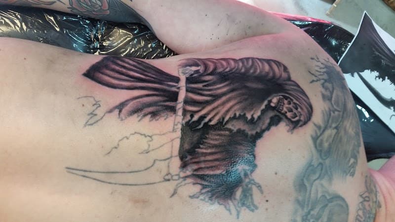 Zwart-wit Grim Reaper tattoo op de rug, deels in wording.