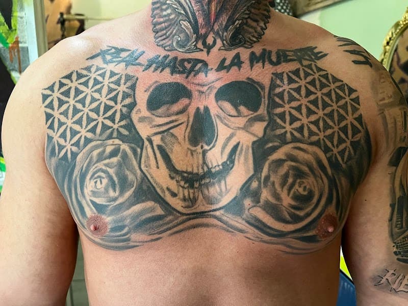 Grote borsttattoo met schedel, rozen en tekst "REAL HASTA LA MUERTE".