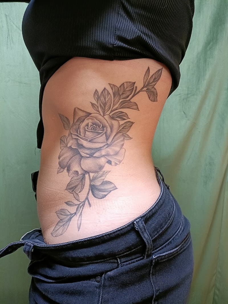 Grote zwart-grijze roos met bladeren op de zij.