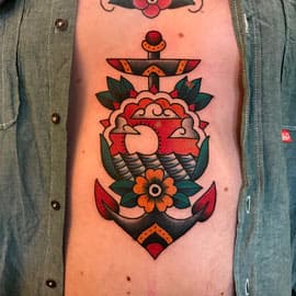 Traditional anker met zonsondergang en bloem op de buik.