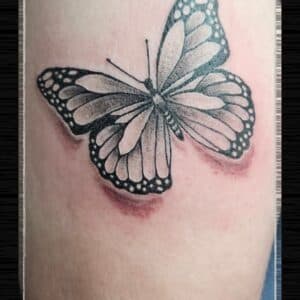Zwart-grijze vlinder tattoo met schaduweffect.