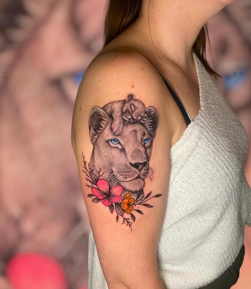 Leeuwin met welpje op haar hoofd en bloemen.