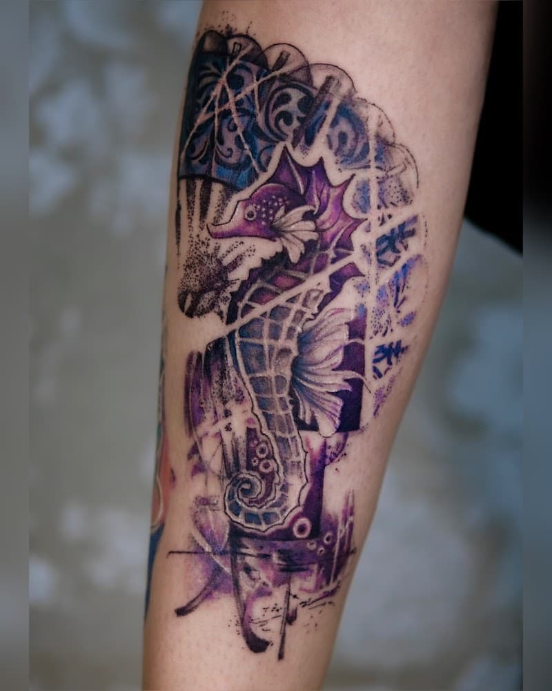 Kleurrijke aquarel zeepaardje tattoo op onderbeen met abstracte lijnen.