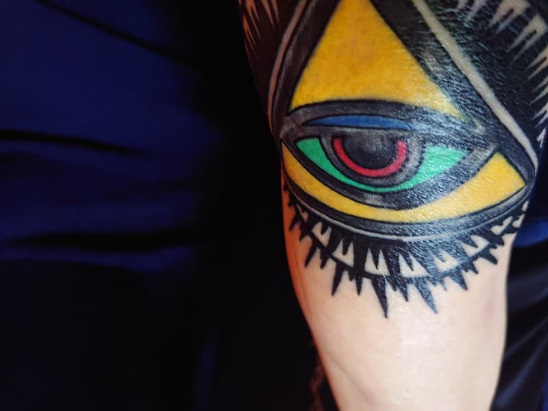 Traditioneel Oog van de Voorzienigheid tattoo in kleur op arm.