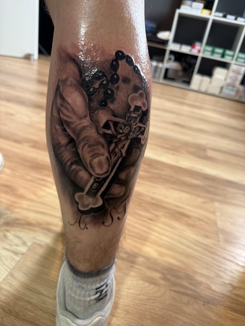 Realistische hand met rozenkrans en kruis op onderbeen.