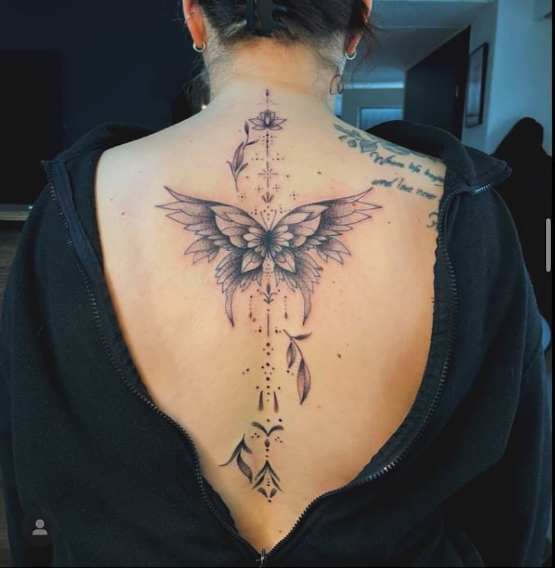 Grote vlinder met ornamenten en dotwork op de ruggengraat.