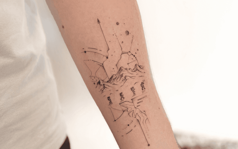 Fineline tattoo van bergbeklimmers, bergen en sterrenbeelden op de onderarm.