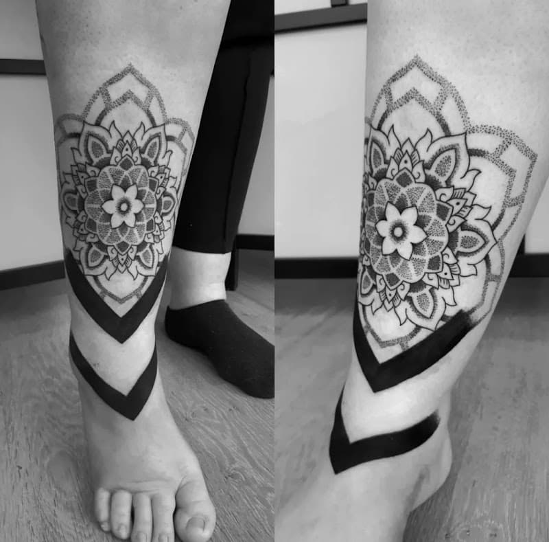 Dotwork mandala met zwarte banden op enkel.