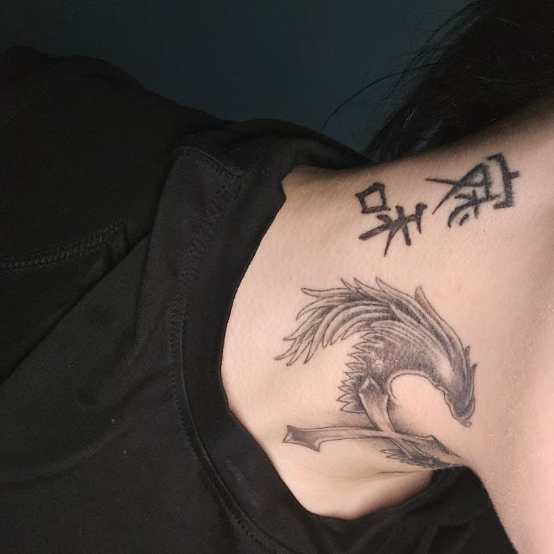 Zwart-wit feniks en Chinese karakters op nek en schouder.