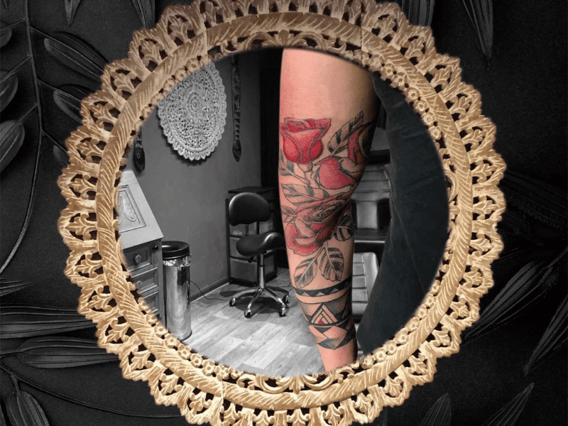 Rode rozen en geometrische tribal band op onderarm.