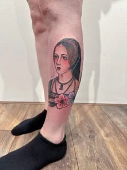 Traditionele tattoo van een historische vrouwenbuste met bloemen op het onderbeen.