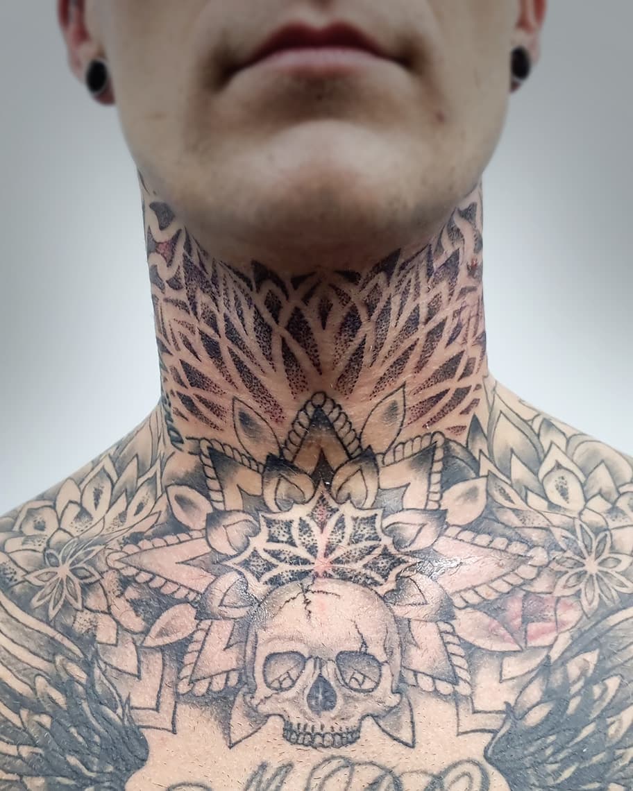 Grote dotwork mandala en schedel tattoo op nek en borst.