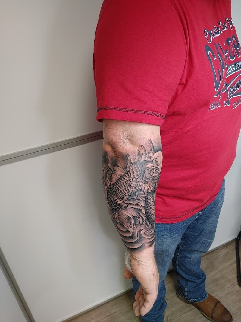 Zwart-grijze Japanse koi karper tattoo op de onderarm.