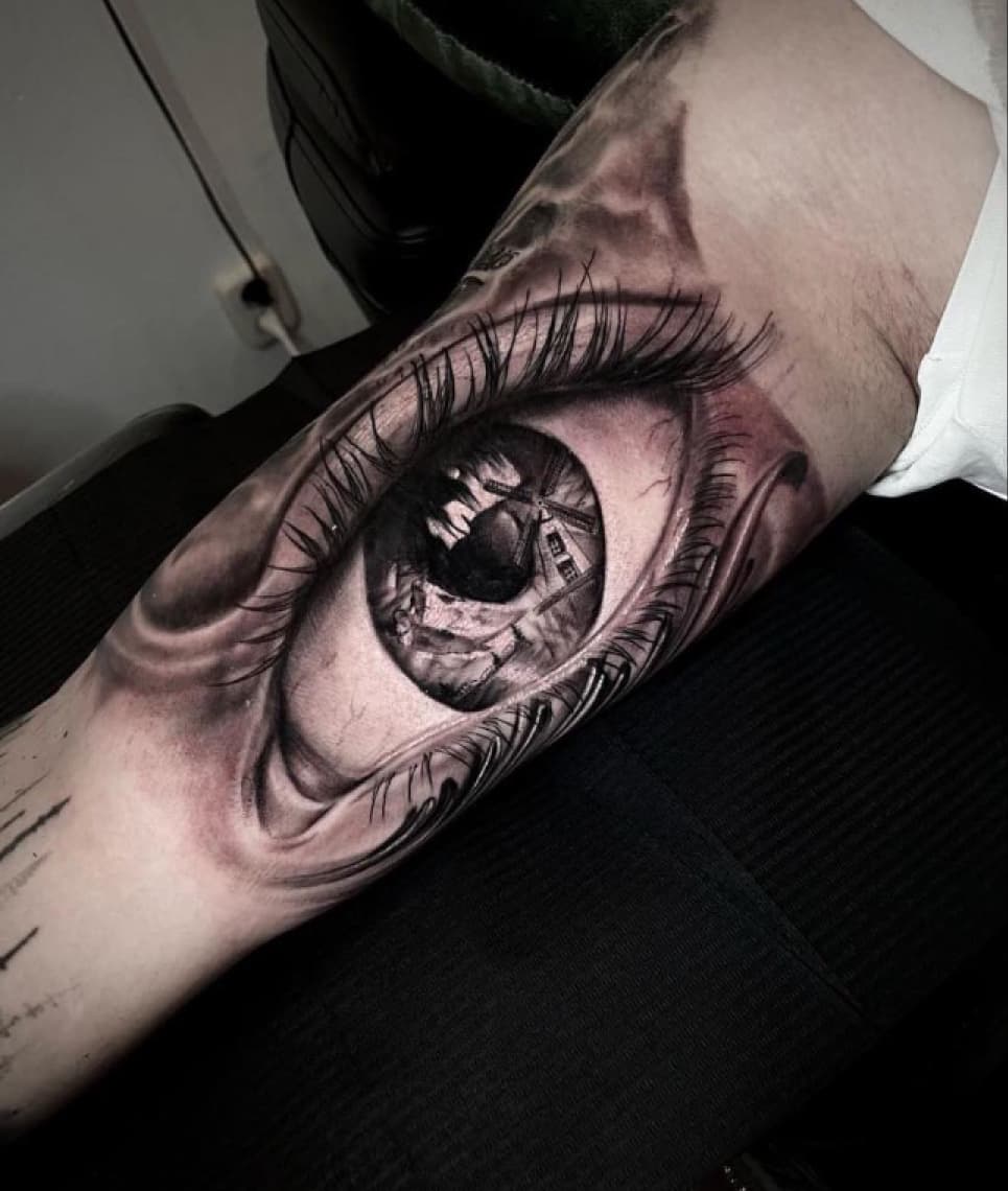 Realistisch oog met een molen in de pupil op de bovenarm.