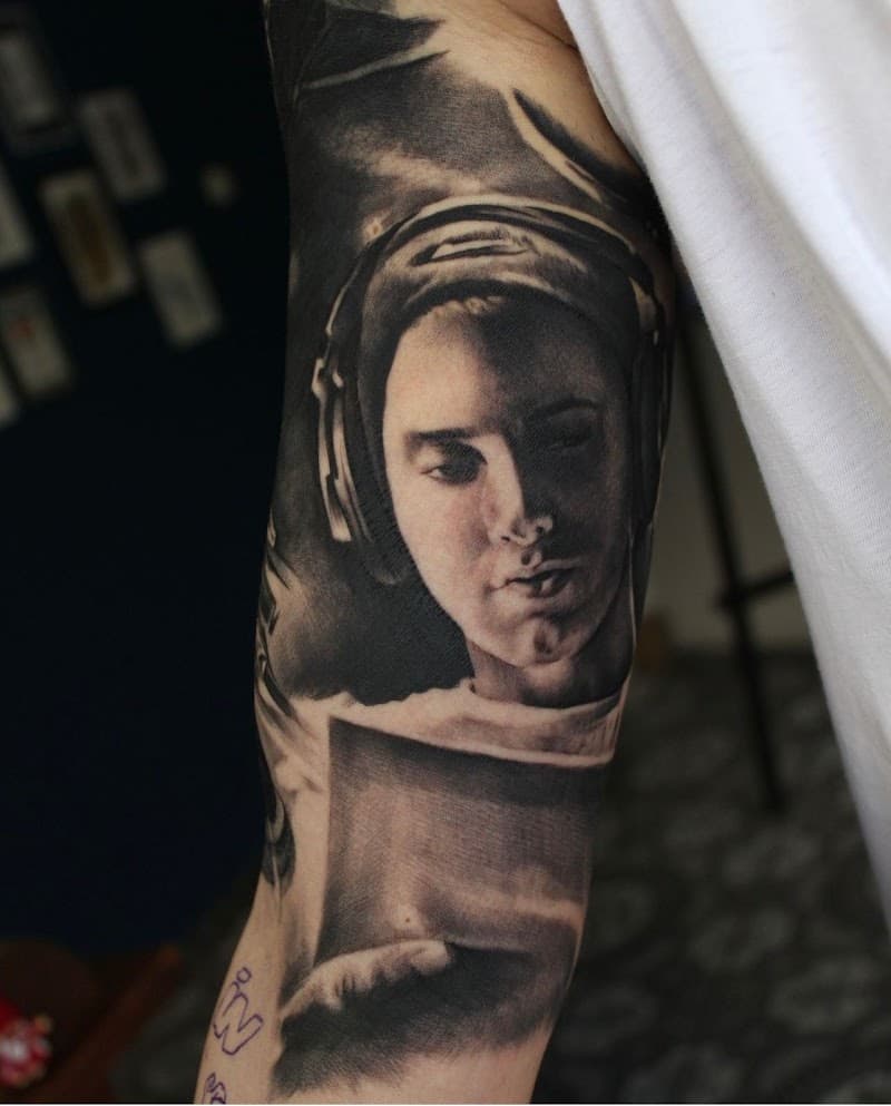 Realistisch portret van Eminem met koptelefoon op bovenarm.