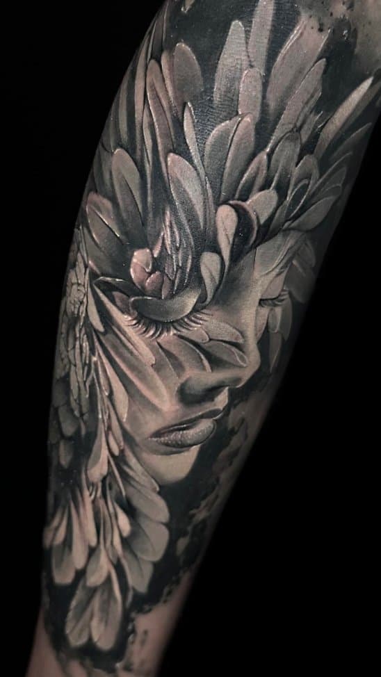 Realistisch portret van een vrouw met bladeren en veren op de arm.