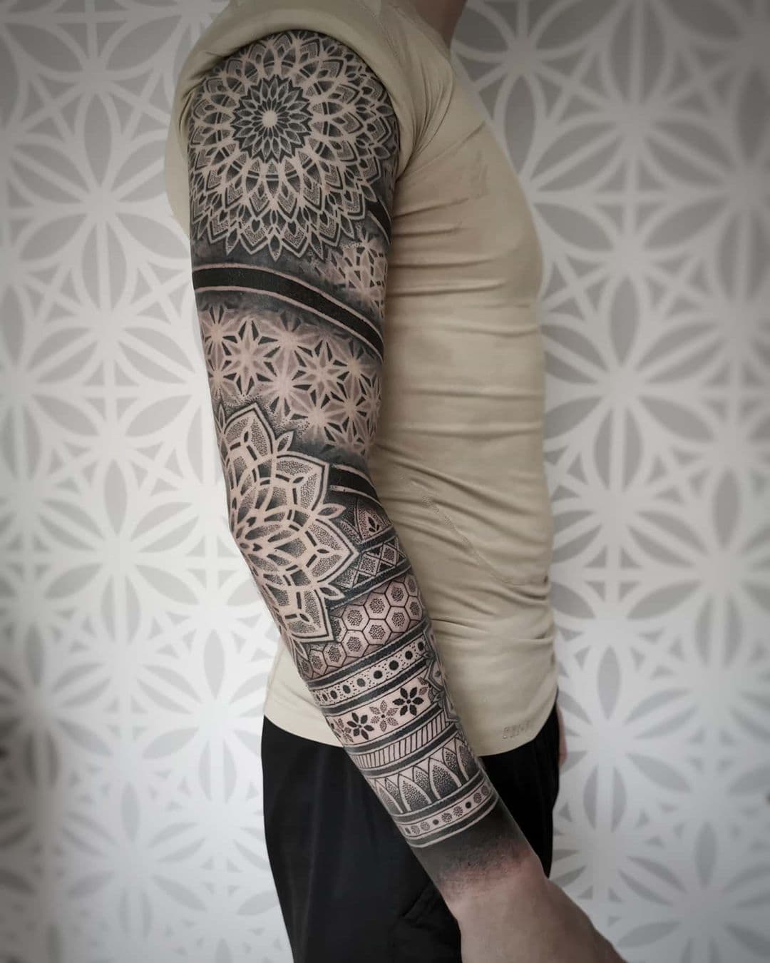 Gedetailleerde geometrische dotwork sleeve met mandala's en patronen.