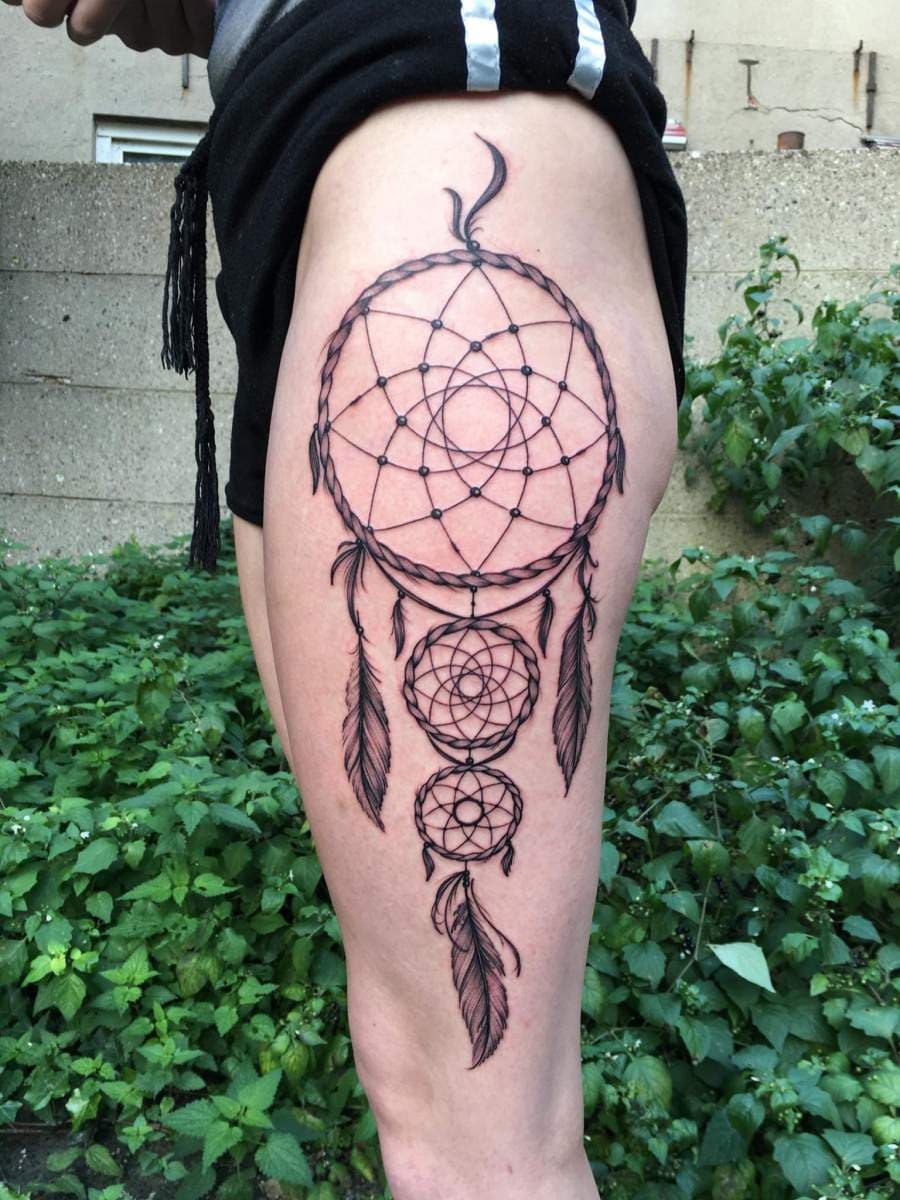 Grote blackwork dromenvanger tattoo op het bovenbeen.
