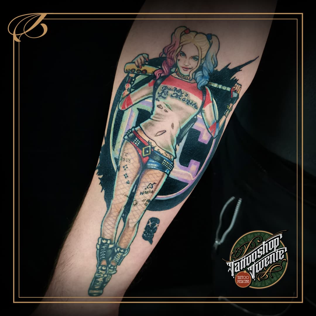 Kleurrijke Harley Quinn tattoo uit Suicide Squad op onderarm.
